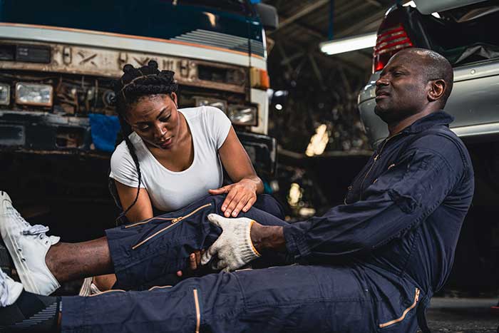 Man holding his knee with a workplace injury