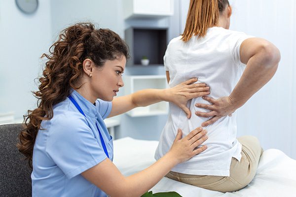 Woman having her back examined