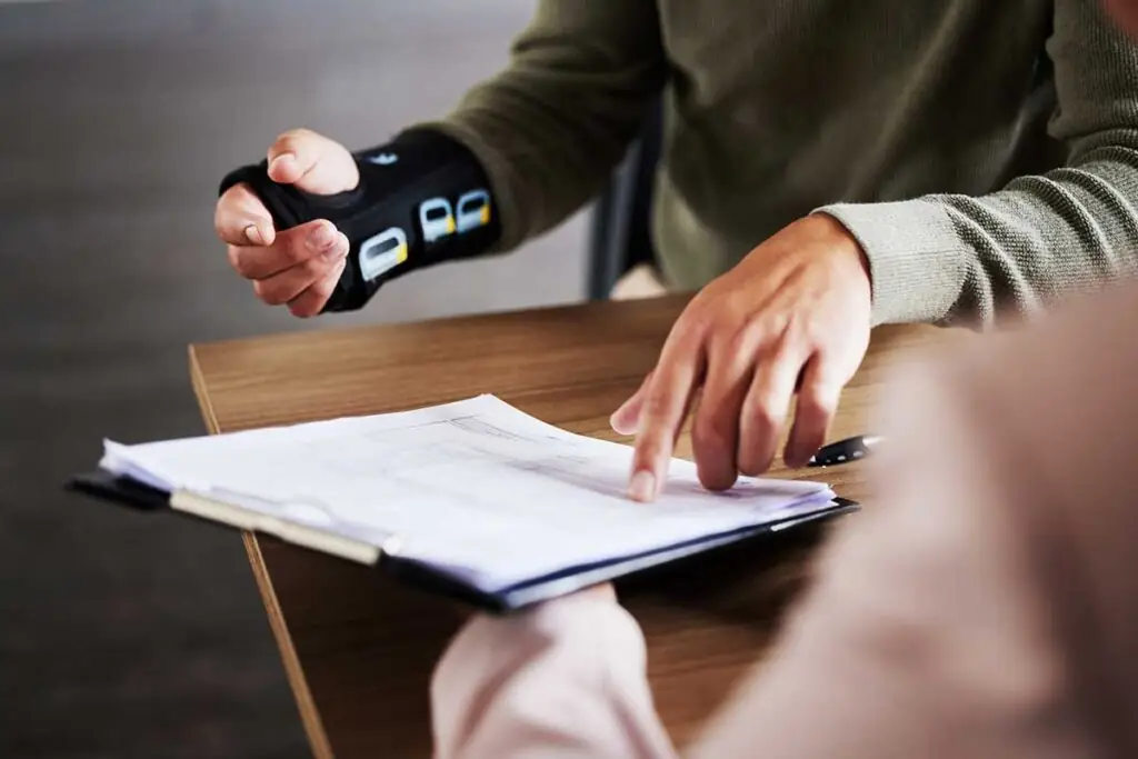 Person with wrist brace reviewing paperwork