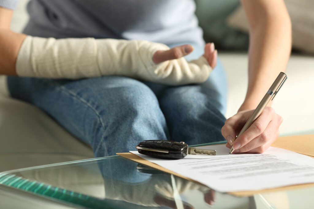 Accident victim completing claim documents, representing OasisFinancial.com’s commitment to fast, compassionate financial assistance.